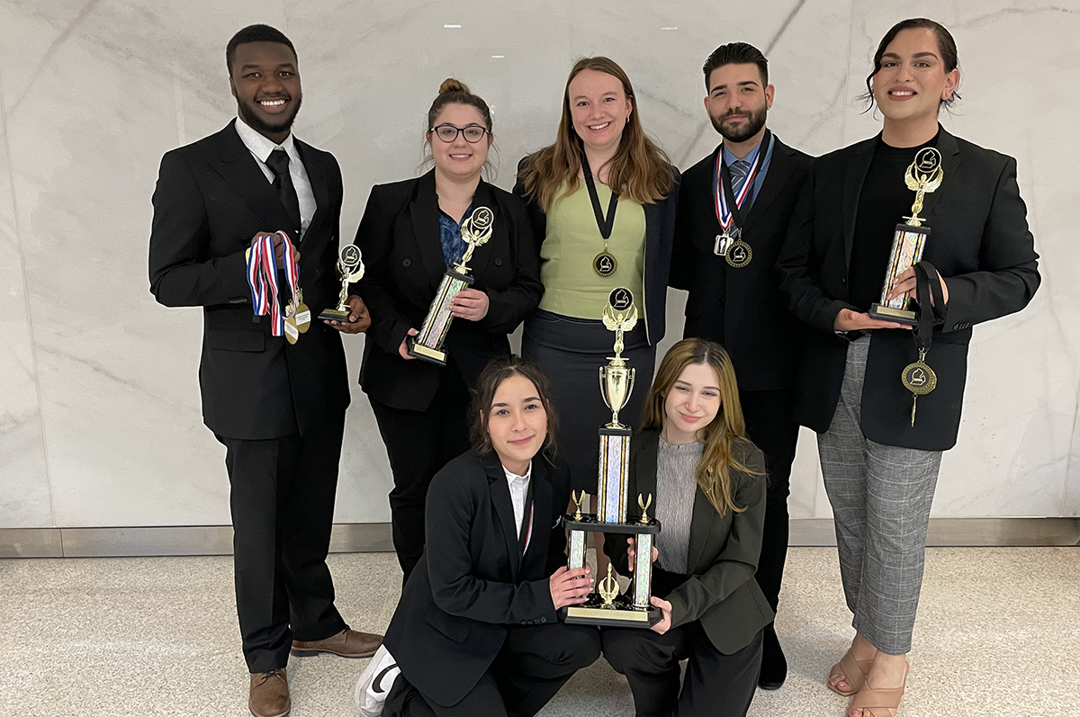 students holding trophies and medals